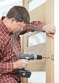 Carpenter at door lock installation