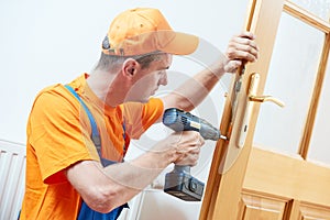 Carpenter at door lock installation or repair photo