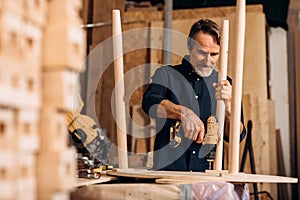 Carpenter drilling a hole in a wooden table