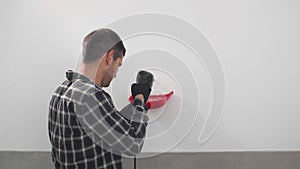 A carpenter drilling holes in the wall