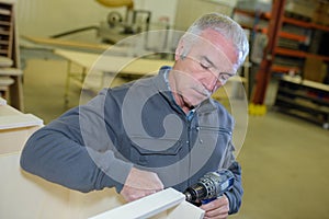 Carpenter drilling the wood