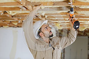 Carpenter drilling wood structure