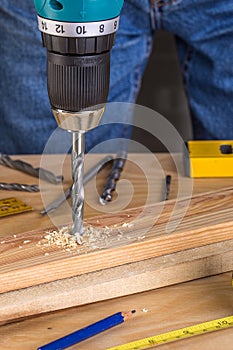 Carpenter drilling wood using portable drilling machine