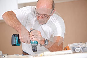 Carpenter drilling into wooden surface