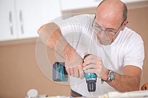 Carpenter drilling into wooden surface