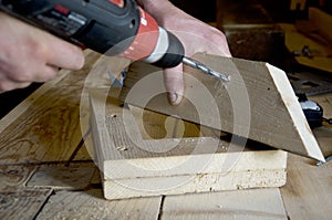 Carpenter drills a hole in the board