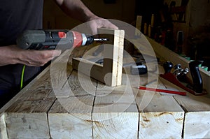 Carpenter drills a hole in the board