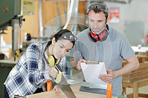 carpenter female apprentice using saw