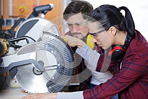 carpenter and female apprentice working together in workshop