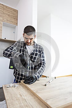 The carpenter finalizing the assembly of the kitchen shelf photo