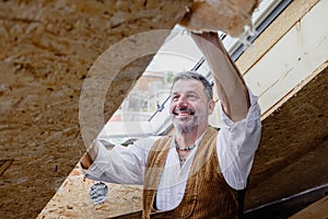 Carpenter fixing insulation material on roof window
