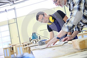 Carpenter giving apprentice carpentry skills