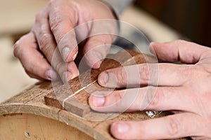 Carpenter glueing wooden parts for drum with bare hands
