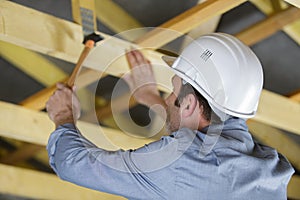 carpenter with hammer hitting nails