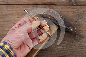 Carpenter hand fingers and hammer