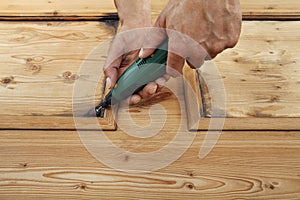 Carpenter hand work the wood with the rotary tool