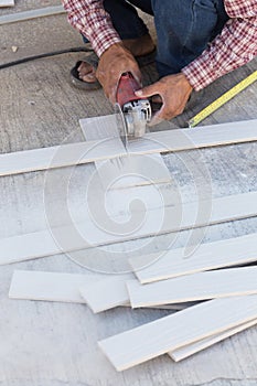 Carpenter hands using electric saw on wood