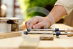 Carpenter hands at work with clamp