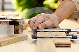 Carpenter hands at work with clamp