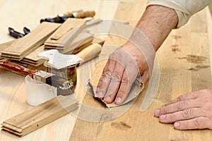 Carpenter hands at work polishing wood