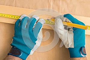 Carpenter handyman using pencil to mark the plank