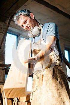 Carpenter in his workshop choosing wood for the next project