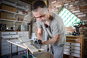 Carpenter holding a measuring tape on the work table