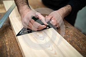 Carpenter holding a set square on the work bench