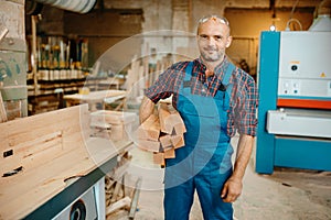 Carpenter holds stack of wooden beams, carpentry