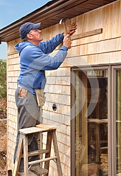 Carpenter installing cedar shingles