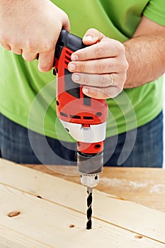 Carpenter or joiner drilling hole photo