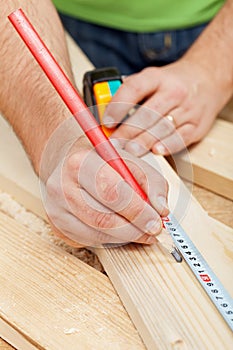 Carpenter or joiner measuring wood photo