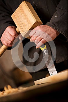 Carpenter or joiner using a chisel and mallet