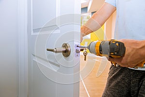 Carpenter at lock installation with wood door