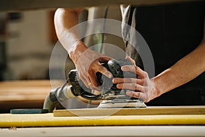 Carpenter is making furniture on order in a workshop