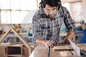 Carpenter making precision cuts to wood using a table saw