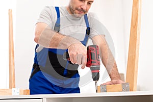 Carpenter Making Table Using Drill Working Indoor In Studio, Cropped