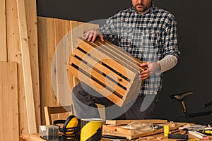 Carpenter making wooden crate in small business woodwork workshop