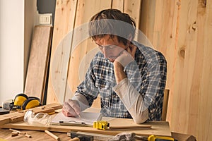 Carpenter making woodwork project notes on clipboard paper