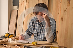 Carpenter making woodwork project notes on clipboard paper