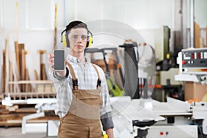 Carpenter man show the mobile phone isolated in carpentry background