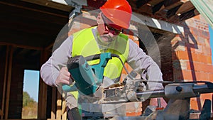 Carpenter man using circular electric saw for cutting wooden boards, woodworker at construction site