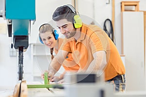 Carpenter man and woman working in workshop