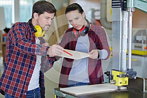 Carpenter man and woman working in workshop as team