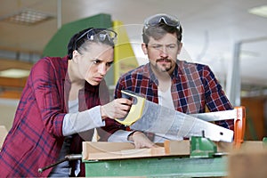 carpenter man and woman working in workshop as team