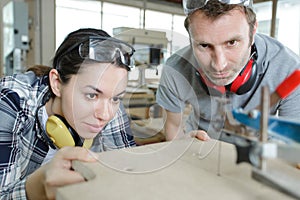 carpenter man and woman in workshop as team