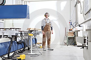 Carpenter man works with wooden planks in the joinery, with computer numerical control center, cnc machine,  isolated on a white