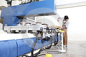 Carpenter man works with wooden planks in the joinery, measure with meter, with computer numerical control center, cnc machine,