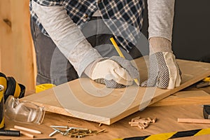 Carpenter marking pine wood plank for cutting