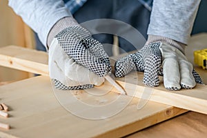 Carpenter marking pine wood plank for cutting